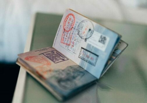 An open passport with travel stamps on a table - ancestral citizenship