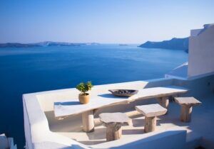 A table outside with chairs overlooking the ocean in Greece. 
