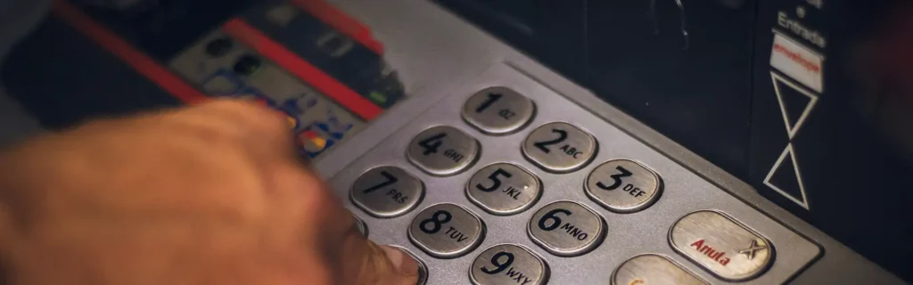Person inserting pin at ATM at top banks in Hungary