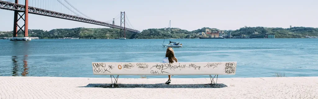 woman sited next to the Tagus river in Lisbon. Portugal